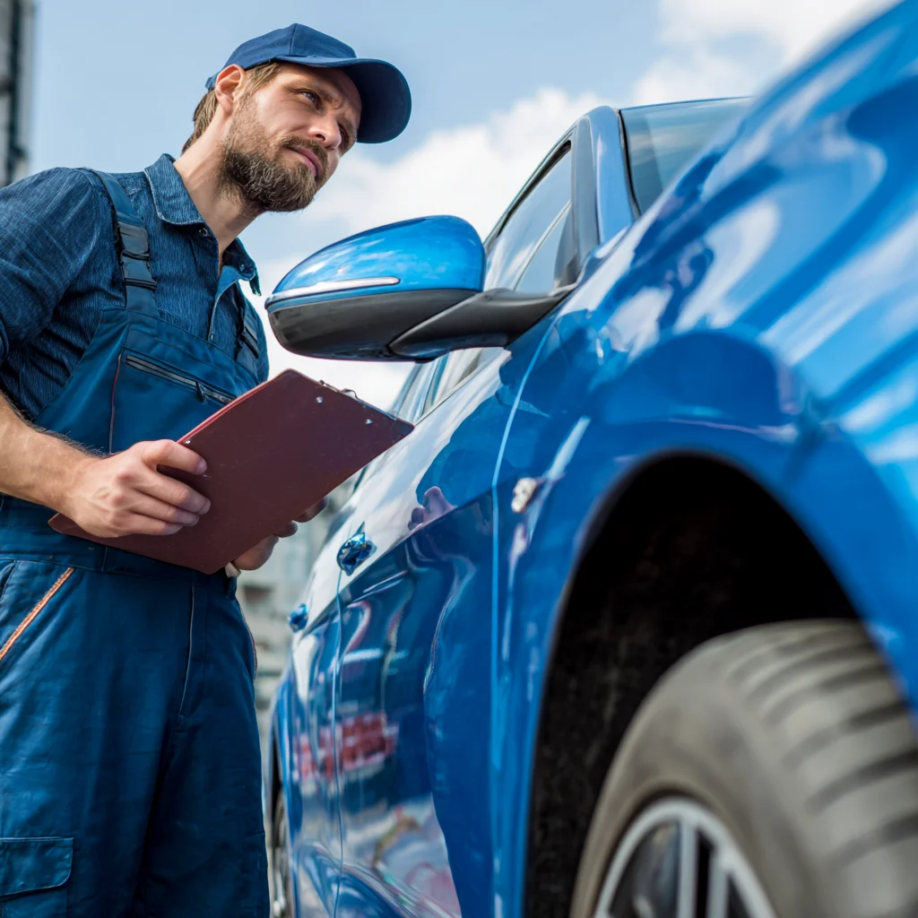 A man inspecting a newly repaired vehicle